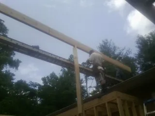 Carpenter setting a ridge beam over a new addition frame — Ice Dam Removal by Roofing Brothers in Grand Ledge