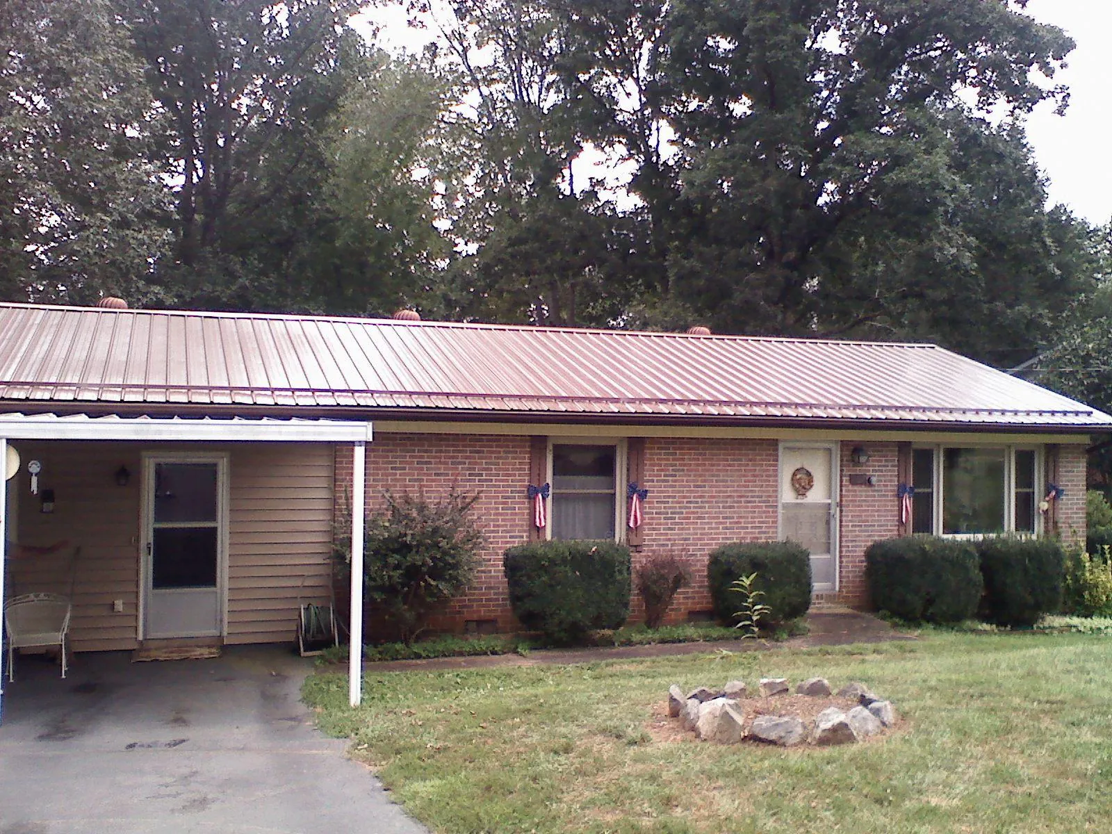 Bronze metal roof and carport on a brick ranch home — Roof Repair work by our crew in Grand Ledge