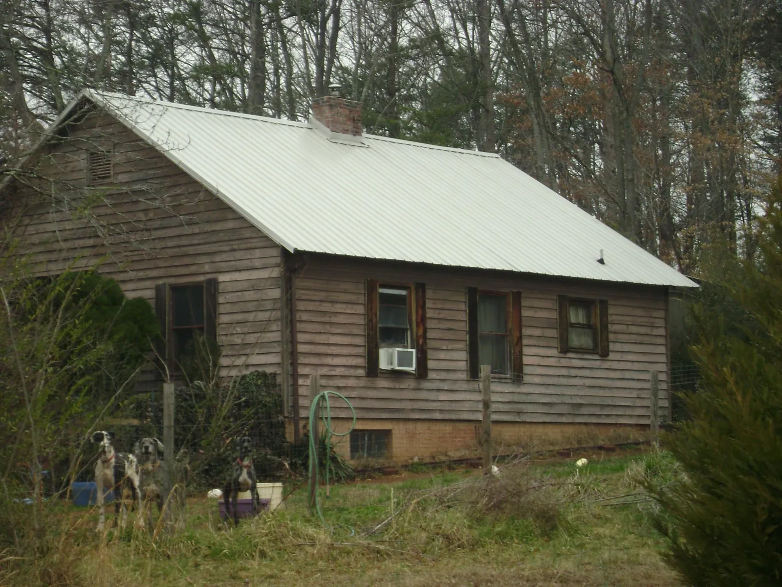 White metal roof on an old wood sided farmhouse, from a Metal Roof Installation job in Grand Ledge